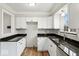 Modern kitchen featuring white cabinets, dark countertops, stainless steel sink and hardwood floors at 4448 Aristocrat Cir, Indianapolis, IN 46235