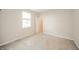 Empty bedroom showing neutral carpet, walls, and open doorway and a large window for natural light at 4720 W Tradwell Dr, New Palestine, IN 46163