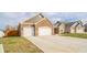 A three-car garage of a single story brick home with a well-maintained lawn at 4720 W Tradwell Dr, New Palestine, IN 46163