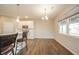 Kitchen nook with a large window and stylish light fixture next to the kitchen bar with seating at 4720 W Tradwell Dr, New Palestine, IN 46163