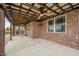 Spacious covered brick patio featuring concrete flooring, wood-beamed ceiling, and ample open space at 4720 W Tradwell Dr, New Palestine, IN 46163
