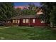 Back exterior view featuring a cozy porch and a lush green lawn at 4754 E 64Th St, Indianapolis, IN 46220