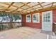 View of the back porch with wooden railing, corrugated awning and door to the red house at 4754 E 64Th St, Indianapolis, IN 46220