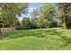 Large grassy backyard bordered by trees, providing a serene and private outdoor space at 4754 E 64Th St, Indianapolis, IN 46220