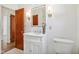 Bathroom with white vanity, modern lighting and fixtures, and a wood door at 4754 E 64Th St, Indianapolis, IN 46220