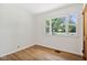 A bedroom with a window, wood-look floors, white walls, and natural light at 4754 E 64Th St, Indianapolis, IN 46220