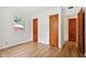 Bright bedroom with hardwood floors, white walls, and two wooden closets; a window provides natural light at 4754 E 64Th St, Indianapolis, IN 46220