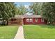 Exterior view of house featuring a covered deck and a yard with green grass and mature trees at 4754 E 64Th St, Indianapolis, IN 46220