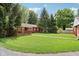Exterior view of house featuring a covered deck and a yard with green grass and mature trees at 4754 E 64Th St, Indianapolis, IN 46220
