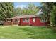 Exterior view of house featuring a covered deck and a yard with green grass and mature trees at 4754 E 64Th St, Indianapolis, IN 46220