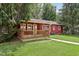 Exterior view of house featuring a covered deck and a yard with green grass and mature trees at 4754 E 64Th St, Indianapolis, IN 46220