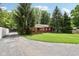 Exterior view of house featuring a covered deck and a yard with green grass and mature trees at 4754 E 64Th St, Indianapolis, IN 46220