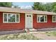 Charming home exterior with a white front door, red siding, and neatly trimmed landscaping at 4754 E 64Th St, Indianapolis, IN 46220