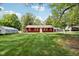 A single-Gathering home with verdant green grass, mature trees, and blue skies creating a picturesque scene at 4754 E 64Th St, Indianapolis, IN 46220