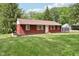 Charming red home featuring a well-manicured lawn, and mature trees at 4754 E 64Th St, Indianapolis, IN 46220