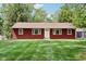 Charming home with a red exterior, well-maintained lawn, and a inviting white front door and trim at 4754 E 64Th St, Indianapolis, IN 46220