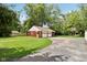 Spacious two-car garage with basketball hoop overlooking expansive green lawn surrounded by trees at 4754 E 64Th St, Indianapolis, IN 46220