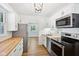 Well-lit kitchen featuring white cabinets, stainless steel appliances, and natural wood countertops at 4754 E 64Th St, Indianapolis, IN 46220