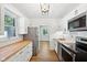 Well-lit kitchen with wooden countertops, white cabinets, stainless steel appliances, and hardwood floors at 4754 E 64Th St, Indianapolis, IN 46220