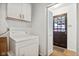 Practical laundry room with washer, dryer, and overhead storage at 4754 E 64Th St, Indianapolis, IN 46220