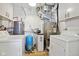 Utility room featuring a furnace, water heater, water softener and two washing machines at 4754 E 64Th St, Indianapolis, IN 46220