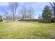 Large backyard with a spacious lawn, mature trees, and a storage shed at 5415 Wallace Ave, Indianapolis, IN 46220