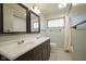Bathroom featuring a double sink vanity, updated fixtures, and a shower with subway tile surround at 5415 Wallace Ave, Indianapolis, IN 46220