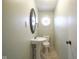 Powder room with a pedestal sink, tile floor, and decorative mirror at 5415 Wallace Ave, Indianapolis, IN 46220