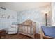Charming Bedroom with hardwood floors, soft lighting, rocking chair and rustic crib at 5415 Wallace Ave, Indianapolis, IN 46220
