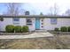 Inviting entrance with a blue door, stone accents, and well-maintained landscaping showcasing this lovely property at 5415 Wallace Ave, Indianapolis, IN 46220