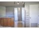 Kitchen showcasing stainless steel refrigerator, wood cabinets, and gray stone accent wall at 5415 Wallace Ave, Indianapolis, IN 46220