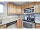 Well-equipped kitchen with stainless steel appliances, light wood cabinetry, and stylish mosaic backsplash at 5415 Wallace Ave, Indianapolis, IN 46220