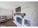 Cozy living room features a gray brick fireplace, wooden mantle, and modern flatscreen TV above at 5415 Wallace Ave, Indianapolis, IN 46220