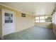Enclosed porch with lots of natural light, a door to the backyard, and green flooring at 5415 Wallace Ave, Indianapolis, IN 46220
