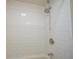 Shower with a chrome shower head, white subway tile surround, and updated fixtures at 5415 Wallace Ave, Indianapolis, IN 46220