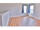 Bedroom with wood floors, two windows with curtains, and light grey walls at 5944 Edelle Dr, Indianapolis, IN 46237