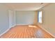 A bright, empty bedroom is painted with pale green walls and wood-look flooring at 5944 Edelle Dr, Indianapolis, IN 46237