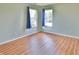 Bedroom with wood floors, two windows with curtains, and light green walls at 5944 Edelle Dr, Indianapolis, IN 46237