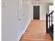 Hallway with dark wood-look floors, white walls, and views of a staircase, front door, and other rooms at 5944 Edelle Dr, Indianapolis, IN 46237