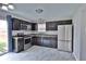 This kitchen features dark cabinets, stainless steel appliances, and a window over the sink at 5944 Edelle Dr, Indianapolis, IN 46237
