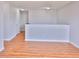 An upstairs loft area featuring a partial dividing wall, wood floors, and a closed door at 5944 Edelle Dr, Indianapolis, IN 46237