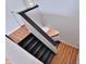 A staircase with black stairs and banister, wooden floors on the upper level, and white walls at 5944 Edelle Dr, Indianapolis, IN 46237