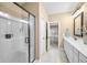 Modern bathroom featuring a glass-enclosed shower, vanity, and tile flooring, with a glimpse into the bedroom at 7236 Sunset Point Dr, Indianapolis, IN 46259
