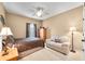 Cozy bedroom featuring neutral walls, carpet, a ceiling fan, a sofa, and traditional-style furniture at 7236 Sunset Point Dr, Indianapolis, IN 46259