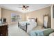 Comfortable bedroom featuring neutral walls, carpet, and ceiling fan, alongside a well-lit window and tasteful furniture at 7236 Sunset Point Dr, Indianapolis, IN 46259