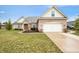 Charming brick home with a well-manicured lawn and attached two-car garage in a suburban neighborhood at 7236 Sunset Point Dr, Indianapolis, IN 46259