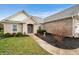 The home's front entrance is framed by brick and mulch, enhanced with lush shrubs and landscaping at 7236 Sunset Point Dr, Indianapolis, IN 46259