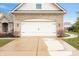 A close up view of the home's brick facade and a large two car garage, with a driveway at 7236 Sunset Point Dr, Indianapolis, IN 46259