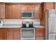 A kitchen featuring wood cabinetry, stainless steel appliances, granite countertops, and tile backsplash at 7236 Sunset Point Dr, Indianapolis, IN 46259