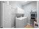 Bright laundry room with front-load washer and dryer, storage cabinets, and shelving at 7236 Sunset Point Dr, Indianapolis, IN 46259